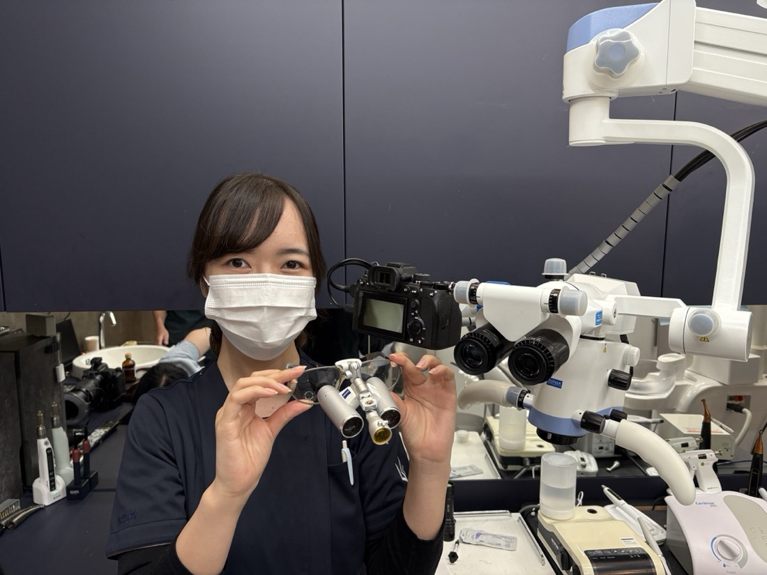 拡大鏡を手にする山﨑有記 歯科医師